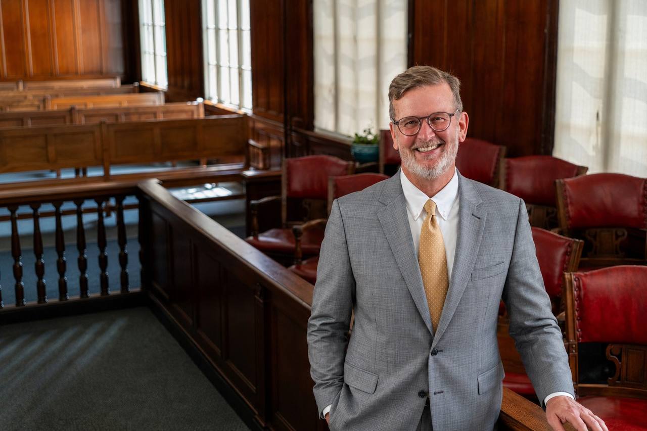 Chris Whitten smiling in a wood-paneled Superior Court courtroom